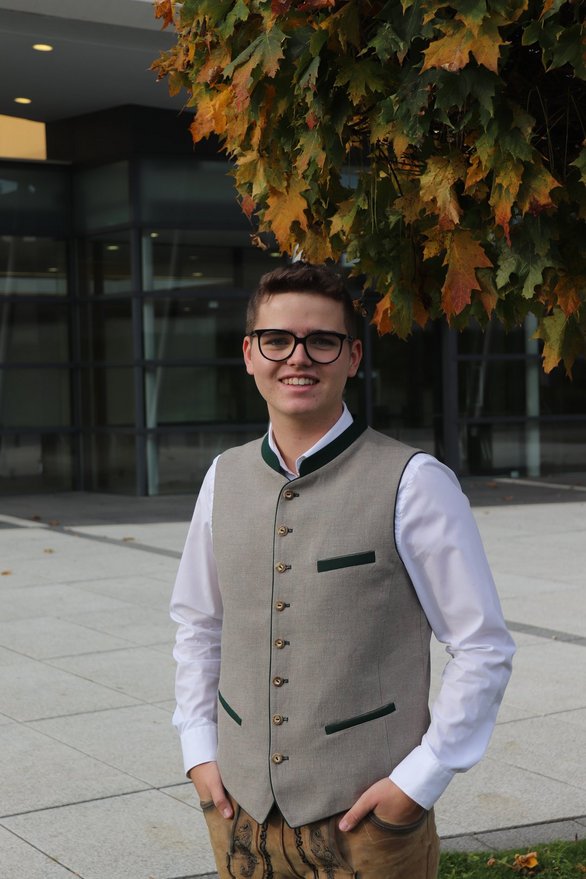 Person in Tracht vor Vaz